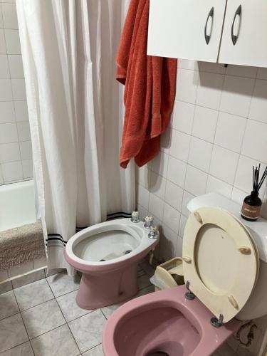 y baño con aseo rosa y ducha. en Habitación individual en departamento compartido, barrio Recoleta en Buenos Aires