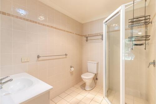 a bathroom with a toilet and a sink and a shower at 74A Sergeant Baker Drive comfortable duplex with beautiful distant water views in Corlette