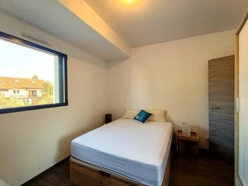 een kleine slaapkamer met een bed en een raam bij Appartement Aix-les-Bains, 3 pièces, 4 personnes - FR-1-555-82 in Aix-les-Bains