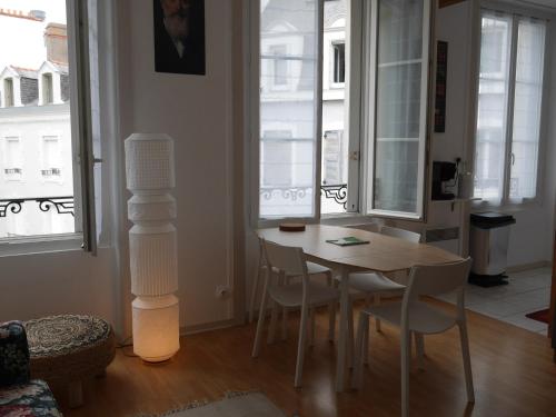 une salle à manger avec une table, des chaises et des fenêtres dans l'établissement Appartement lumineux au coeur de Le Palais, 2 chambres, proche commerces et bus, idéal vacances - FR-1-418-225, au Palais