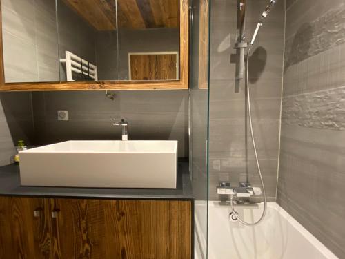 une salle de bain avec un lavabo blanc et une douche dans l'établissement T2 avec Coin Nuit, Sud, Vue Montagnes, Wi-Fi, Non-Fumeur - FR-1-437-99, à La Clusaz