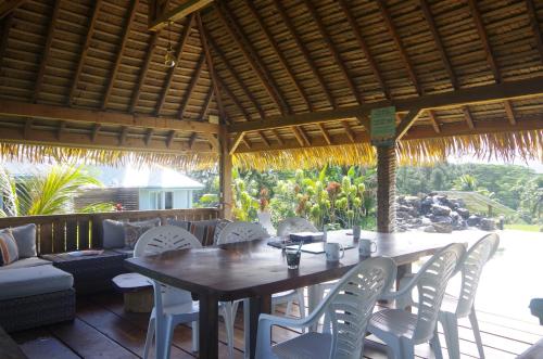 Vai Iti Lodge في Afaahiti: طاولة وكراسي خشبية تحت مظلة خشبية