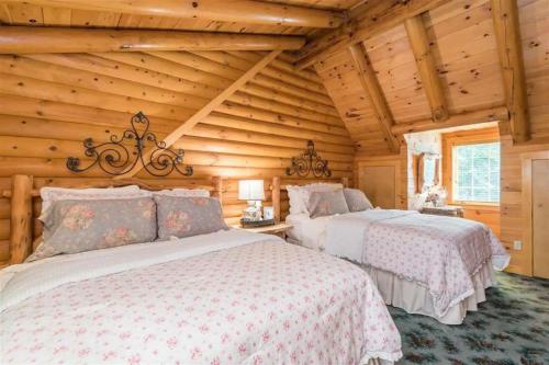 sypialnia z 2 łóżkami w drewnianym domku w obiekcie Firefly Creek w mieście Gatlinburg