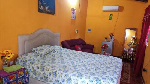 Hospedaje Luque في Luque: غرفة نوم بسرير وكرسيين ارجوانيين