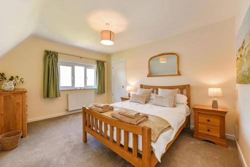 ein Schlafzimmer mit einem großen Bett und einem Spiegel in der Unterkunft Sea Breeze in Rustington