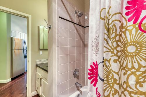 a bathroom with a shower curtain with a flower at Belltown Court Space Needle Studio in Seattle