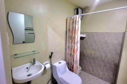 La salle de bains est pourvue d'un lavabo, de toilettes et d'un miroir. dans l'établissement Cozy Studio Condo in San Jose del Monte, 