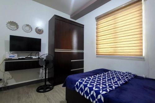 - une chambre avec un lit et une télévision à écran plat dans l'établissement Cozy Studio Condo in San Jose del Monte, 