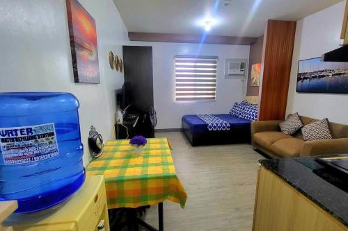 ein Wohnzimmer mit einer Küche und ein Wohnzimmer mit einem Tisch in der Unterkunft Cozy Studio Condo in San Jose del Monte 