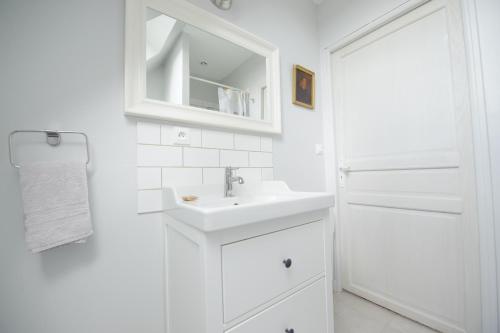 a white bathroom with a sink and a mirror at Villa Clément Sens Appart'Hotel in Sens