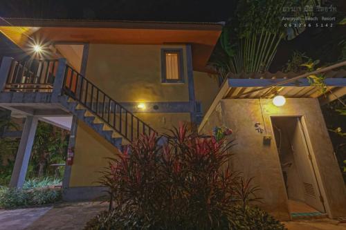 a house with a staircase and a door at night at บ้านพักปราณบุรี อารยา บีช รีสอร์ท in Ban Nong Sua