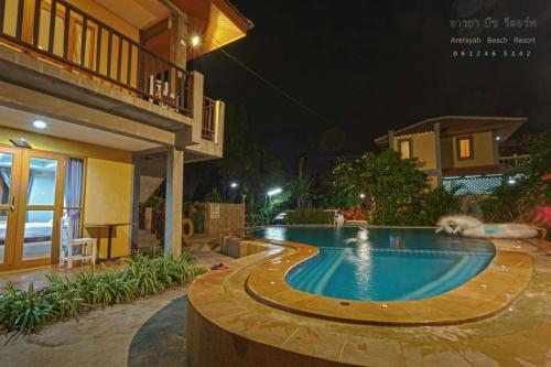 a dog laying in a swimming pool at night at บ้านพักปราณบุรี อารยา บีช รีสอร์ท in Ban Nong Sua