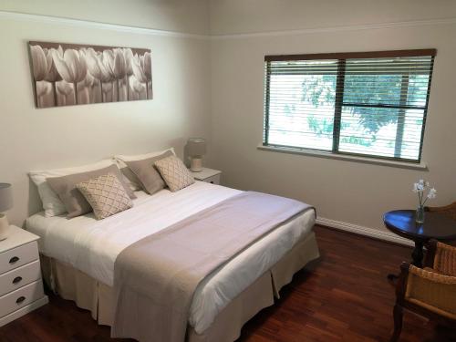 a bedroom with a large white bed with a window at Springwood Homestead B&B in Metricup