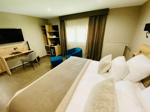 um quarto de hotel com uma grande cama branca e uma secretária em Domaine de Suzel em Vignieu