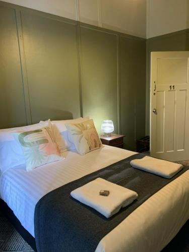 sypialnia z dużym łóżkiem z dwoma ręcznikami w obiekcie Tyalgum Hotel w mieście Tyalgum