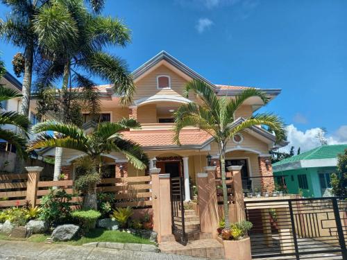 a house with palm trees in front of it at Tagaytay Rest House in Tagaytay