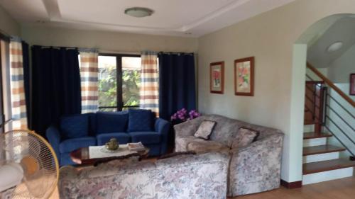 a living room with a blue couch and a staircase at Tagaytay Rest House in Tagaytay