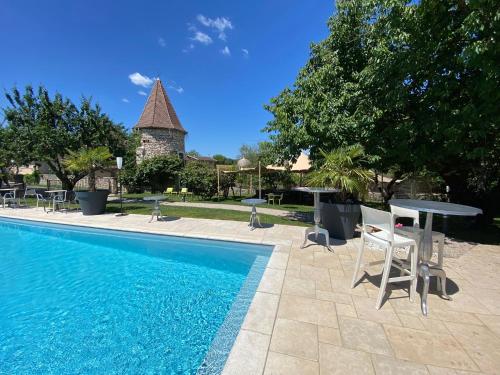 uma piscina com cadeiras e uma mesa e um edifício em Domaine de Suzel em Vignieu