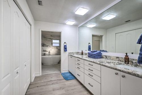 a white bathroom with a tub and a sink at Spacious Family Home w/ Backyard in Gainesville! in Gainesville