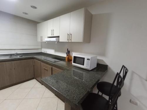 a kitchen with a counter with a microwave on it at Departamento con piscina frente al mar en Manta in Manta