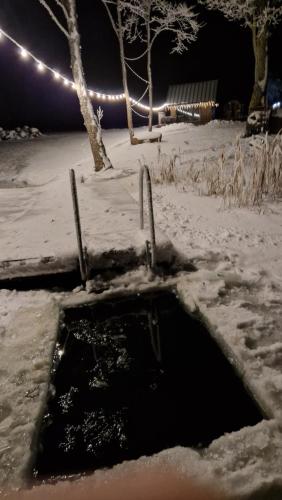 a pothole in the snow at night with lights at Auksi puhkemaja-1 in Auksi
