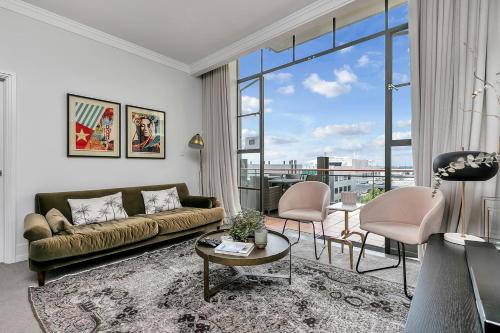 a living room with a couch and a large window at The Corporate's Selection + CP! in Auckland