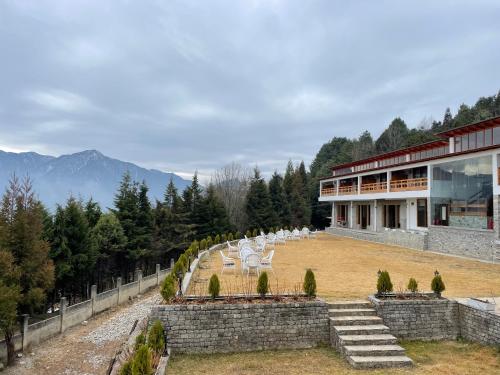 a view of a building with chairs on a field at Timilo Boutique in Tawang