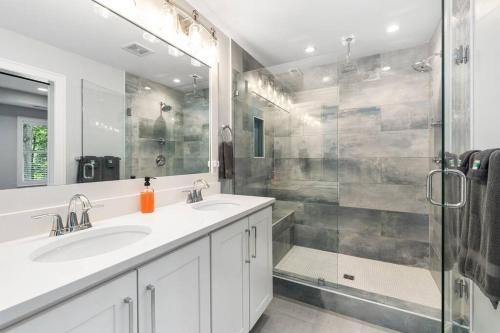 a bathroom with two sinks and a shower at New Home, Dock, Home Theatre Projector, Hot Tub, Fire Pit, Kayaks in Winchester
