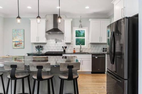 a kitchen with a black refrigerator and a table with stools at New Home, Dock, Home Theatre Projector, Hot Tub, Fire Pit, Kayaks in Winchester