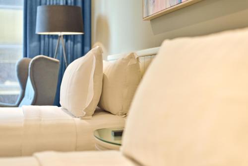 a living room with a white couch and a lamp at Ashley Sabang Jakarta in Jakarta