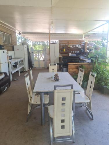 a table and chairs in a room with a kitchen at Non power Campsite. in Karimba