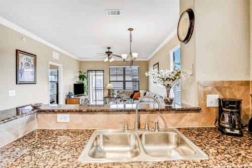 a kitchen with a sink and a living room at Bella Piazza Getaway in Davenport