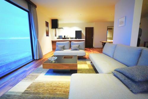 a living room with two couches and a large window at HERO VILLA ocean suite in Ishigaki Island