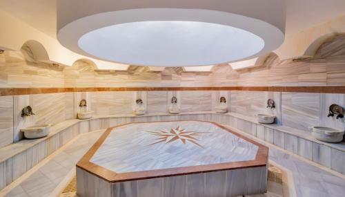 a large bathroom with three toilets and a large ceiling at Holiday Park Resort - Ultra All İnclusive in Okurcalar