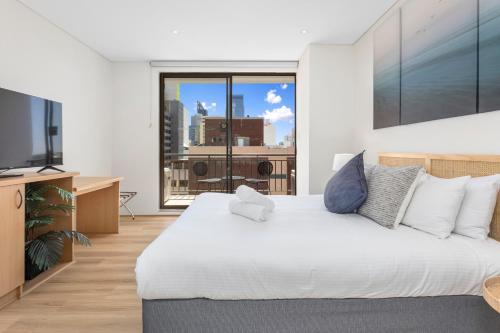 1 dormitorio con cama grande y ventana grande en Perth Cbd Retreat Victoria Ave 1br Apt en Perth