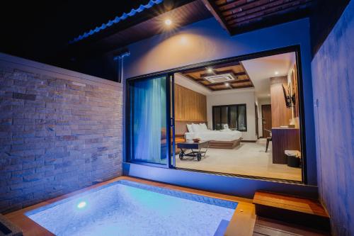 a room with a swimming pool in the middle of a house at Malabar Pool Villa Phuket in Phuket Town