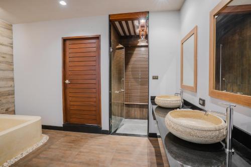 uma casa de banho com 2 lavatórios e uma banheira em Malabar Pool Villa Phuket em Cidade Phuket