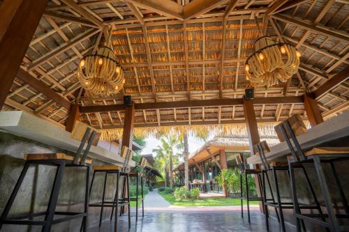 a row of chairs under a wooden ceiling with chandeliers at Malabar Pool Villa Phuket in Phuket Town