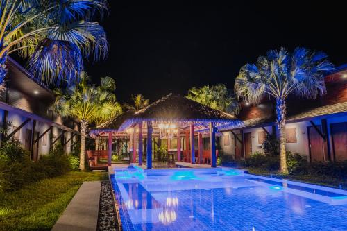 a villa with a swimming pool at night at Malabar Pool Villa Phuket in Phuket Town