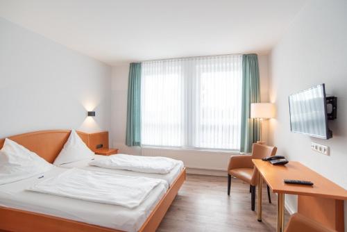 a hotel room with a bed and a desk at Butjadinger Hof in Burhave