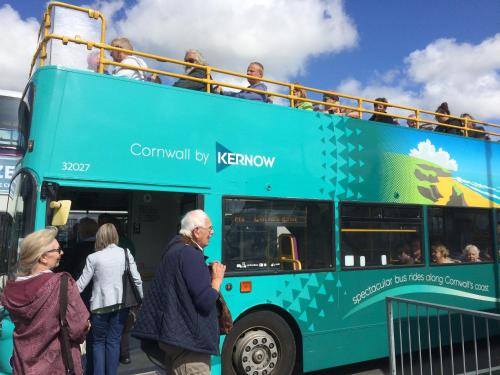 a group of people boarding a double decker bus at Stylish Sea View Apartment with Parking in Penzance
