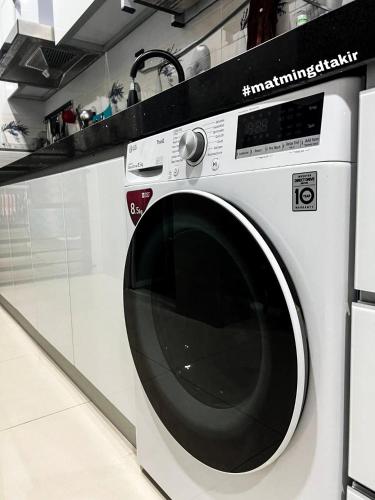 a white washing machine sitting in a kitchen at MatmingDtakir (near beach & drawbridge) in Kuala Terengganu