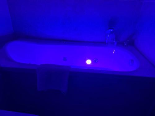a bath tub with a blue light in a bathroom at STONE Apartment in Žilina