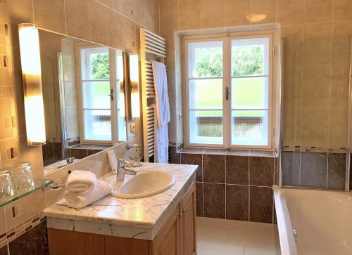a bathroom with a sink and a tub and a mirror at Murhof Hotel in Frohnleiten