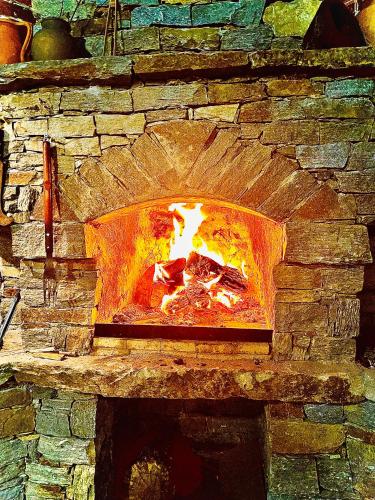 a stone oven with a fire in it at Bóris House in Ognyanovo