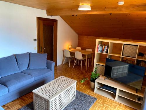 a living room with a blue couch and a table at Haus JoLoMo in Mallnitz