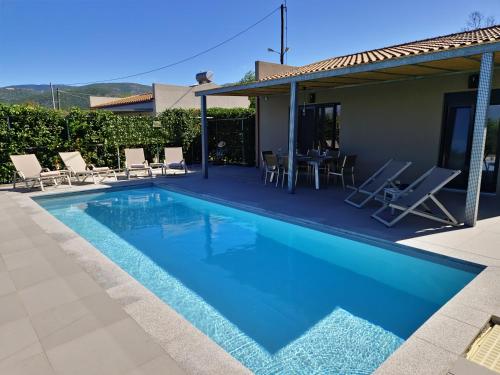 a swimming pool with chairs and a house at ONAR - LUXURY VILLAS in Argostoli