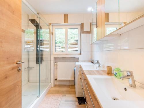 a bathroom with two sinks and a shower at Beautiful Holiday Home in Feldkirch with Garden in Feldkirch