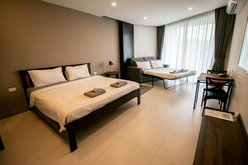 a bedroom with a bed and a living room at Escape Condominiums Beachfront Suites - Mae Phim in Rayong