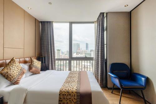ein Hotelzimmer mit einem Bett, einem Stuhl und einem Fenster in der Unterkunft Yoyo Apartment Jiedeng Metropolis Branch, Beijing Road in Guangzhou